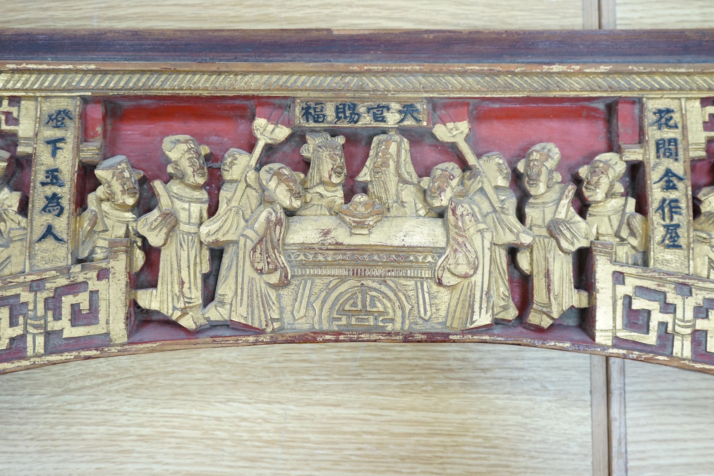 A Chinese carved figural gilt wood and stained arched panel, 94cm wide. Condition - worn with age and use